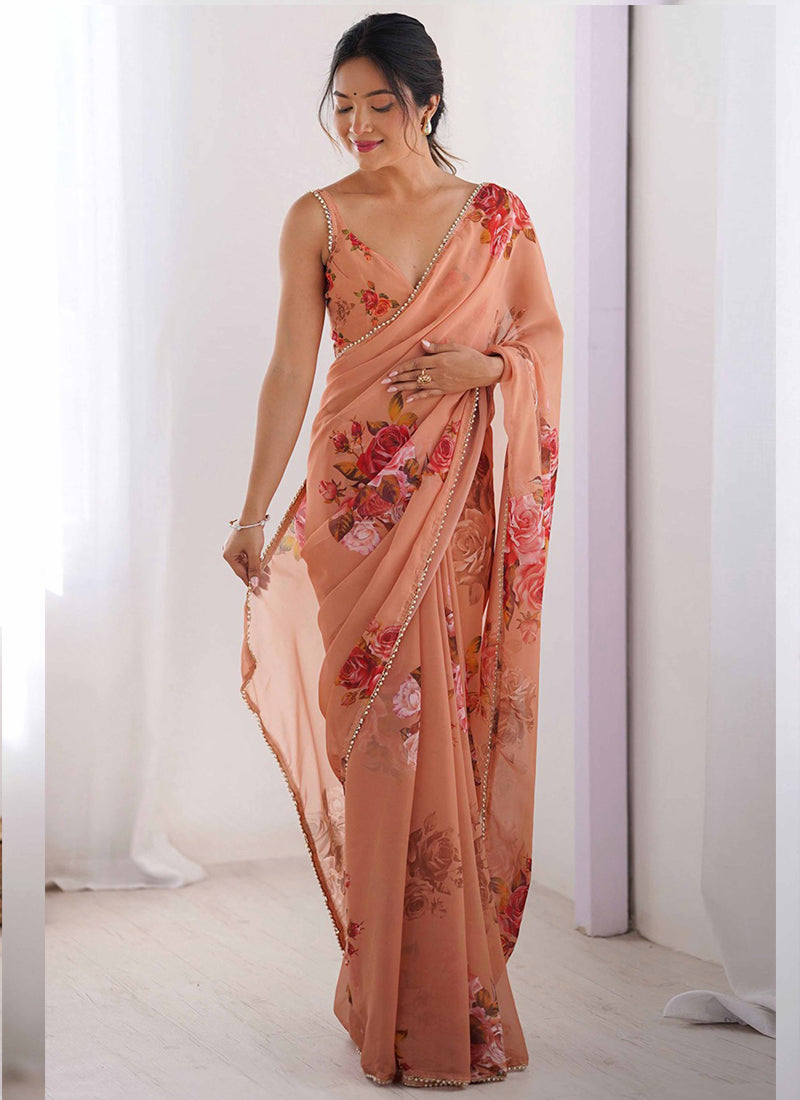 Close up of peach georgette silk saree with intricate printed patterns and a beaded moti work border.