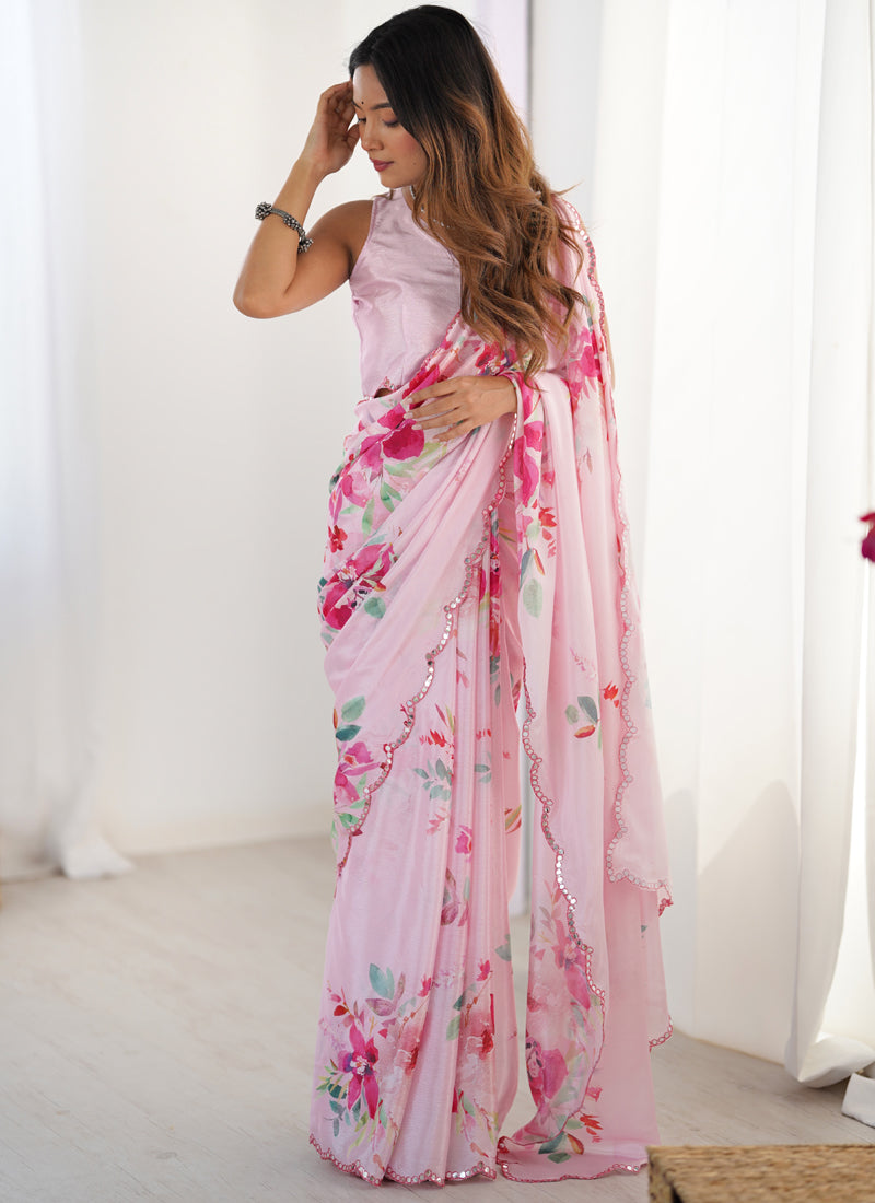 Baby girl wearing a baby pink Chinon silk designer saree with a glittery mirror-work border for a festive look.