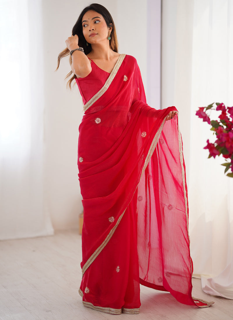 Model wearing a vibrant red Fandy silk saree with intricate Moti and Val sequence embroidery and a heavy lace border.