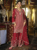 Woman wearing a maroon chinon silk palazzo suit with detailed gota patti embroidery