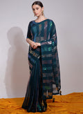 Model wearing a teal georgette saree with intricate sequin embroidery and an unstitched blouse.