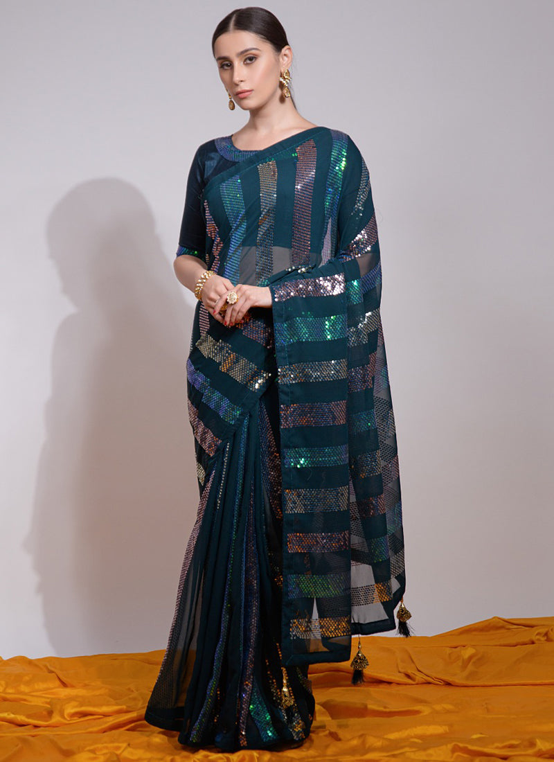 Model wearing a teal georgette saree with intricate sequin embroidery and an unstitched blouse.