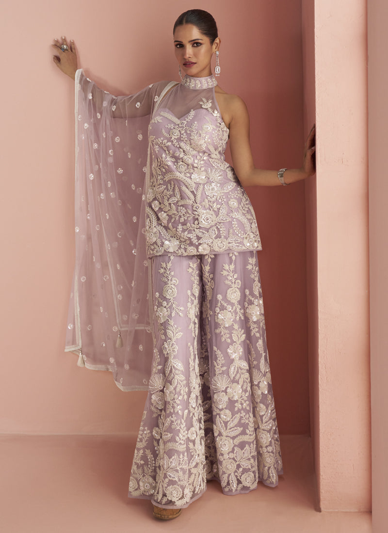 Woman wearing a light lavender net palazzo suit with intricate embroidery and Gota Patti beadwork
