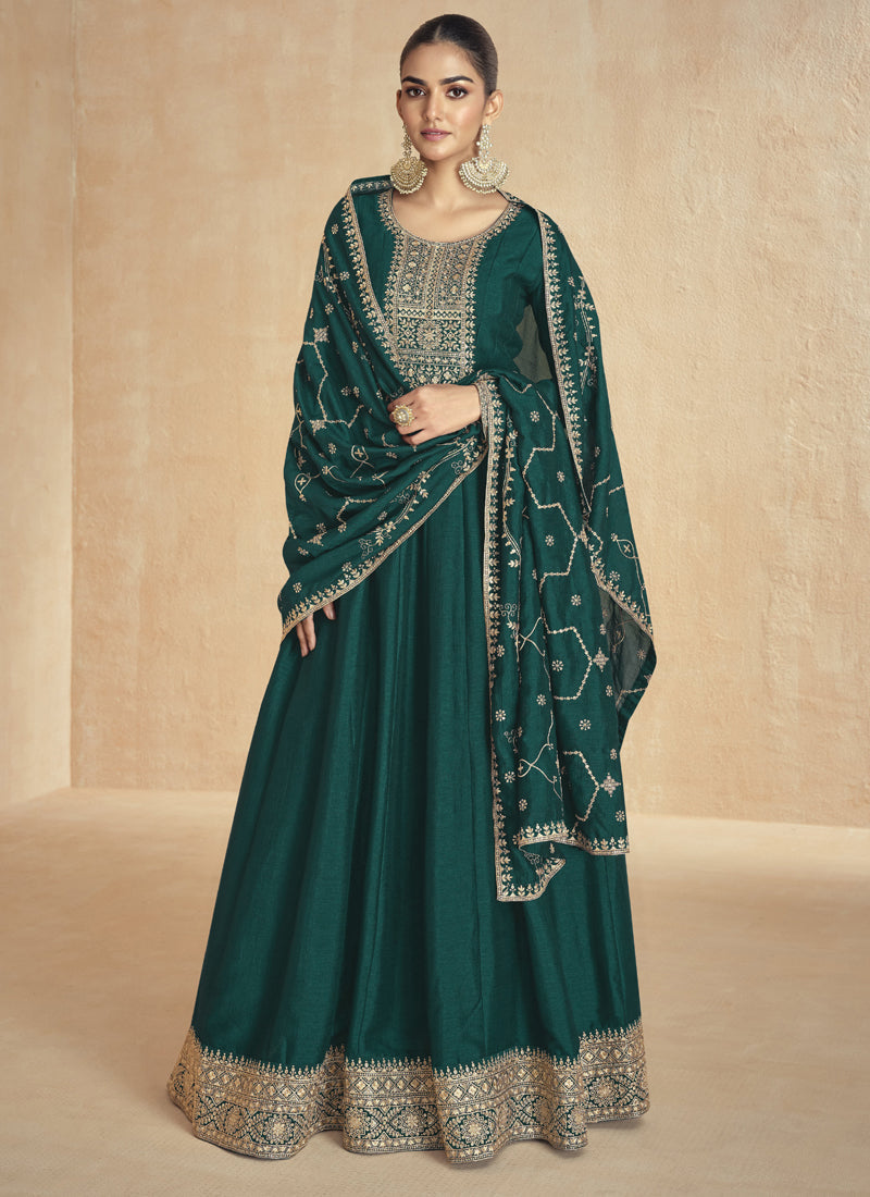 Woman wearing a green silk Anarkali suit with gold embroidery, gota patti, and zari work.