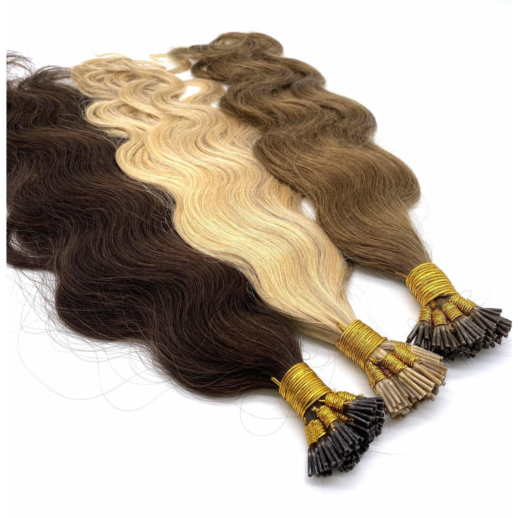 Close up of 18 inch wavy I-Tip human hair extensions in dark brown and blonde-highlighted colors.