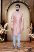 A toddler wearing a soft pink brocade patterned kurta with white polo pyjamas