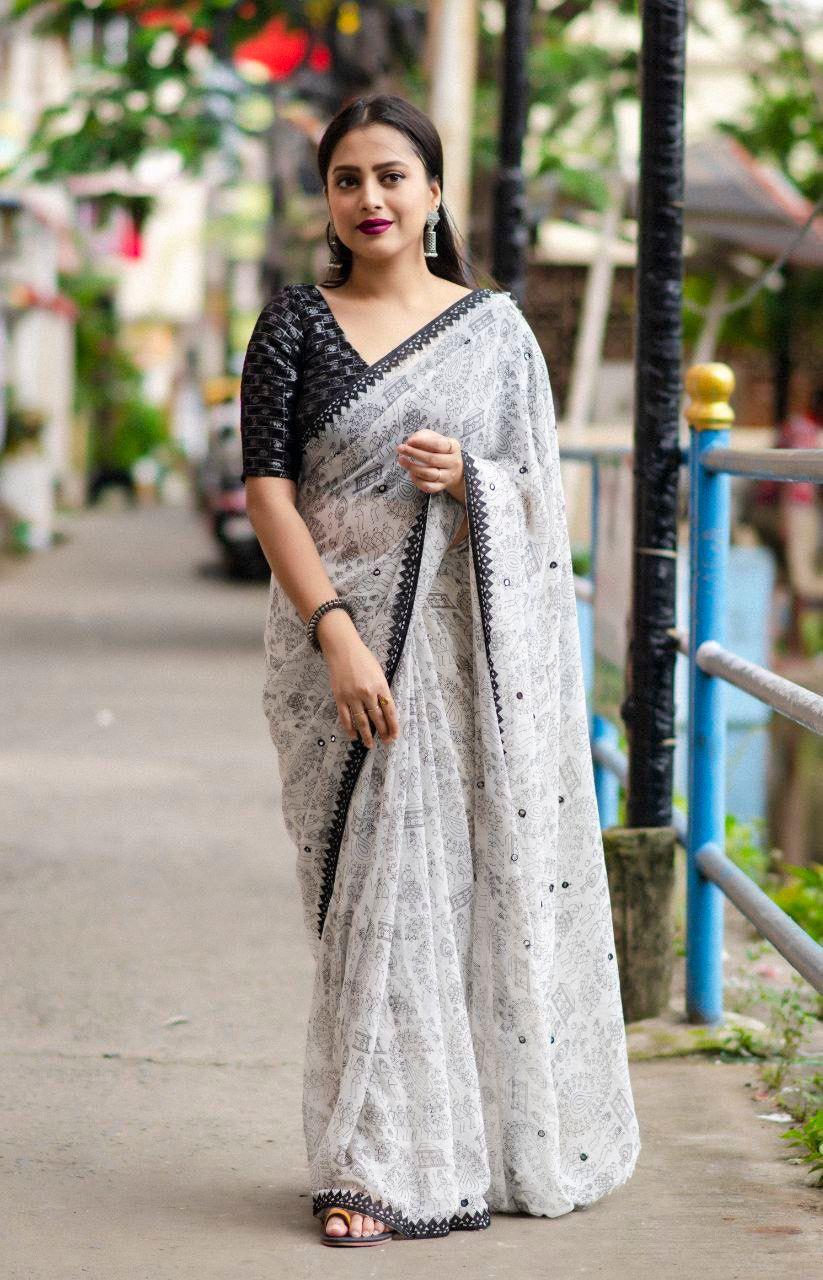 Black pure georgette Warli printed saree with aari mirror work and contrast tie & dye silk blouse.