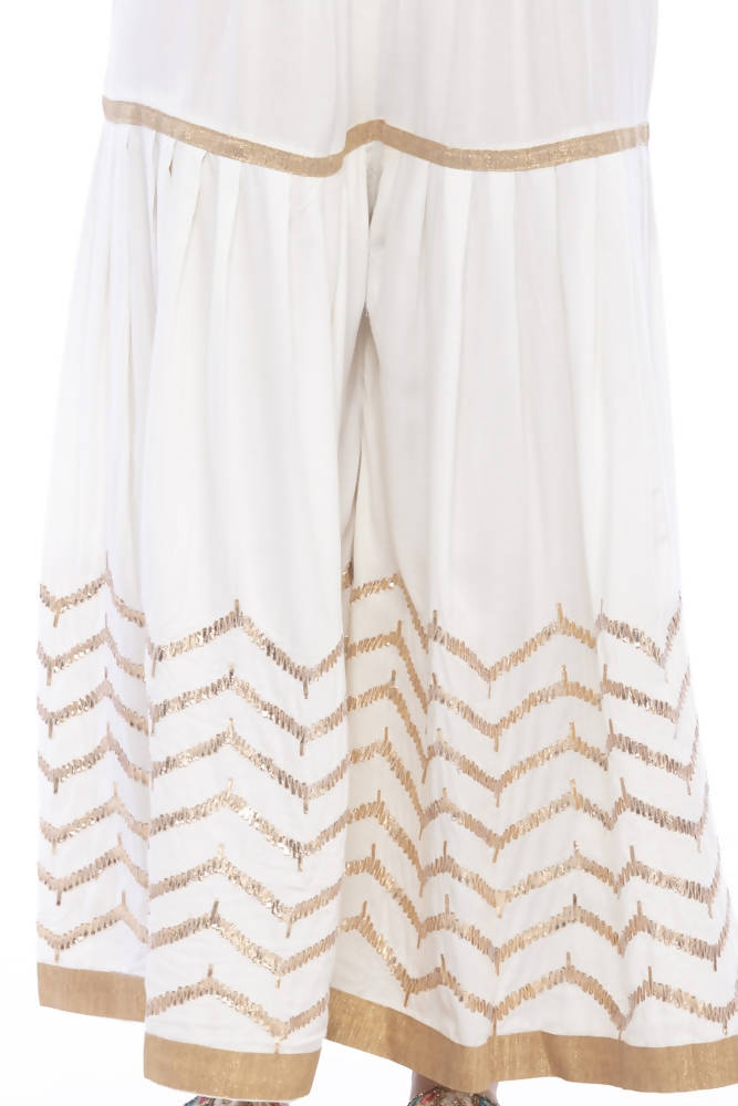 Young girl wearing an off-white cotton sharara with elegant Gota print detailing