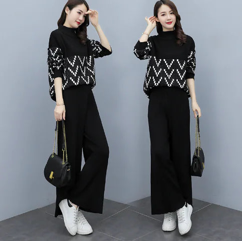 A woman wearing a black two-piece knit set featuring a sweater with geometric sleeve patterns and wide-leg pants.
