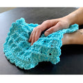 Close up of a crochet washcloth featuring a textured waffle stitch pattern