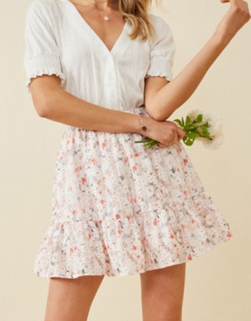 A pink eyelet embroidered floral skirt featuring an elastic waistband and delicate lace-like detailing.