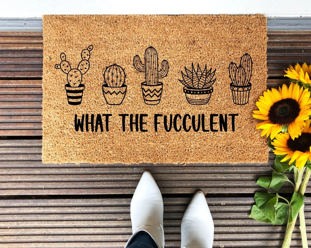Plant-themed 'What The Fucculent' doormat made of natural coir with a non-slip rubber backing.