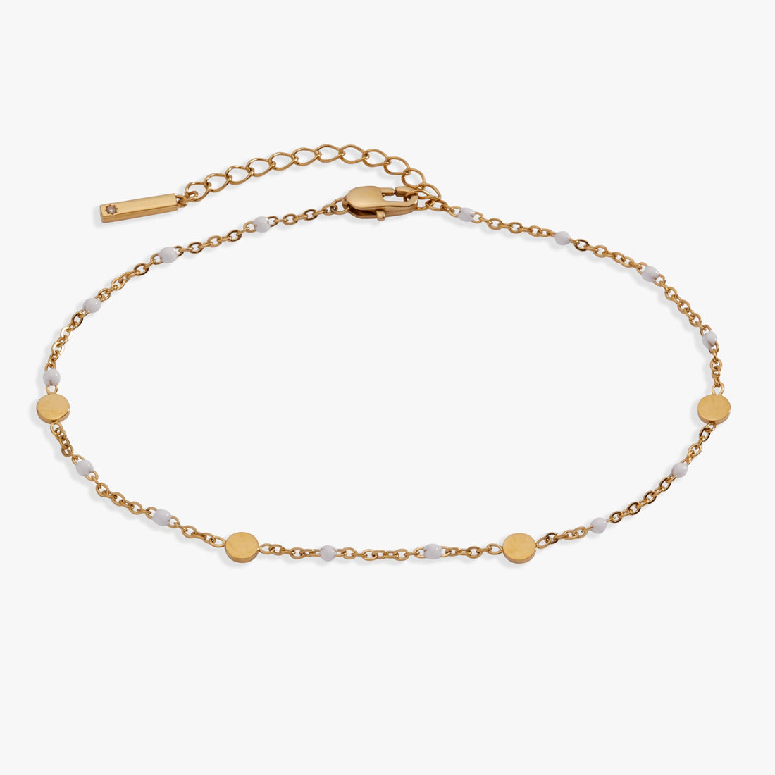 White enameled chain anklet with gold-plated coin stations on a light background