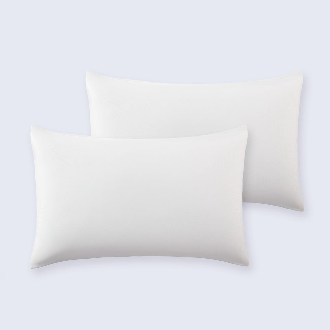 Set of two smooth white cooling pillowcases arranged neatly on a bed.
