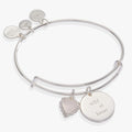 Silver-tone expandable wire bangle with a Wild at Heart engraved charm and a heart charm with a sparkling pink crystal.