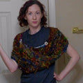 Finished Wild Peacock Wrap featuring vibrant fibers and button details