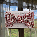 Baby wearing a red and white window pane check bamboo head wrap with a knotted bow detail.