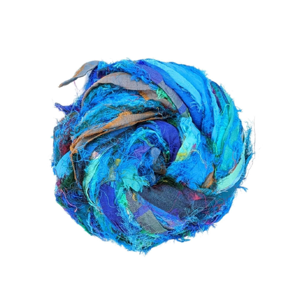 A skein of colorful, textured Windswept Sari Silk Ribbon Yarn handmade by artisans.
