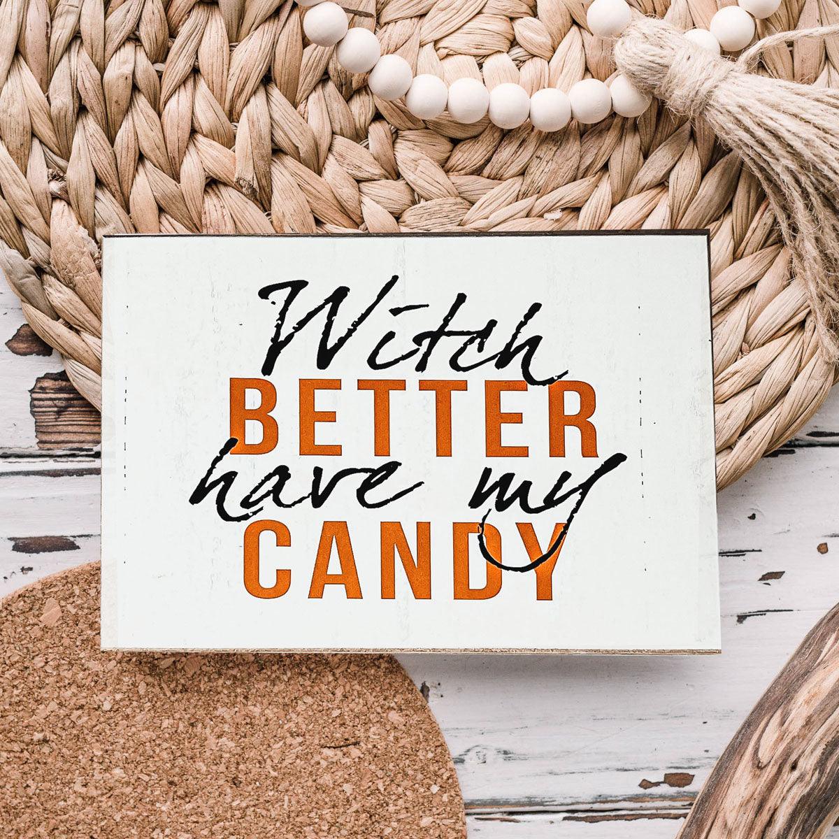 Rustic wooden Halloween sign with white background and text reading Witch Better Have My Candy in black and orange lettering