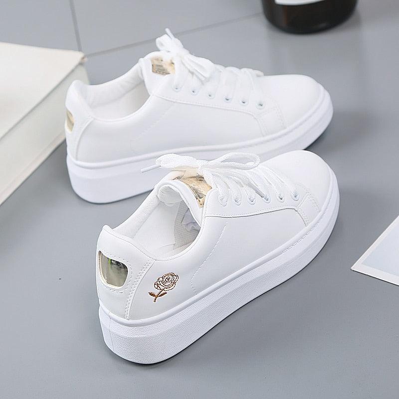 Women's white casual low-top sneakers with floral embroidery and white laces.