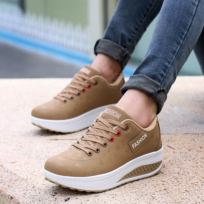 Modern women's PU leather flatform sneakers with lace-up closure in a sleek sporty design.