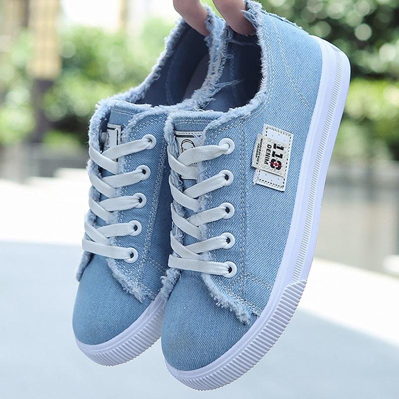 Classic white low-top canvas sneakers with leather-wrapped toe and elastic heel support