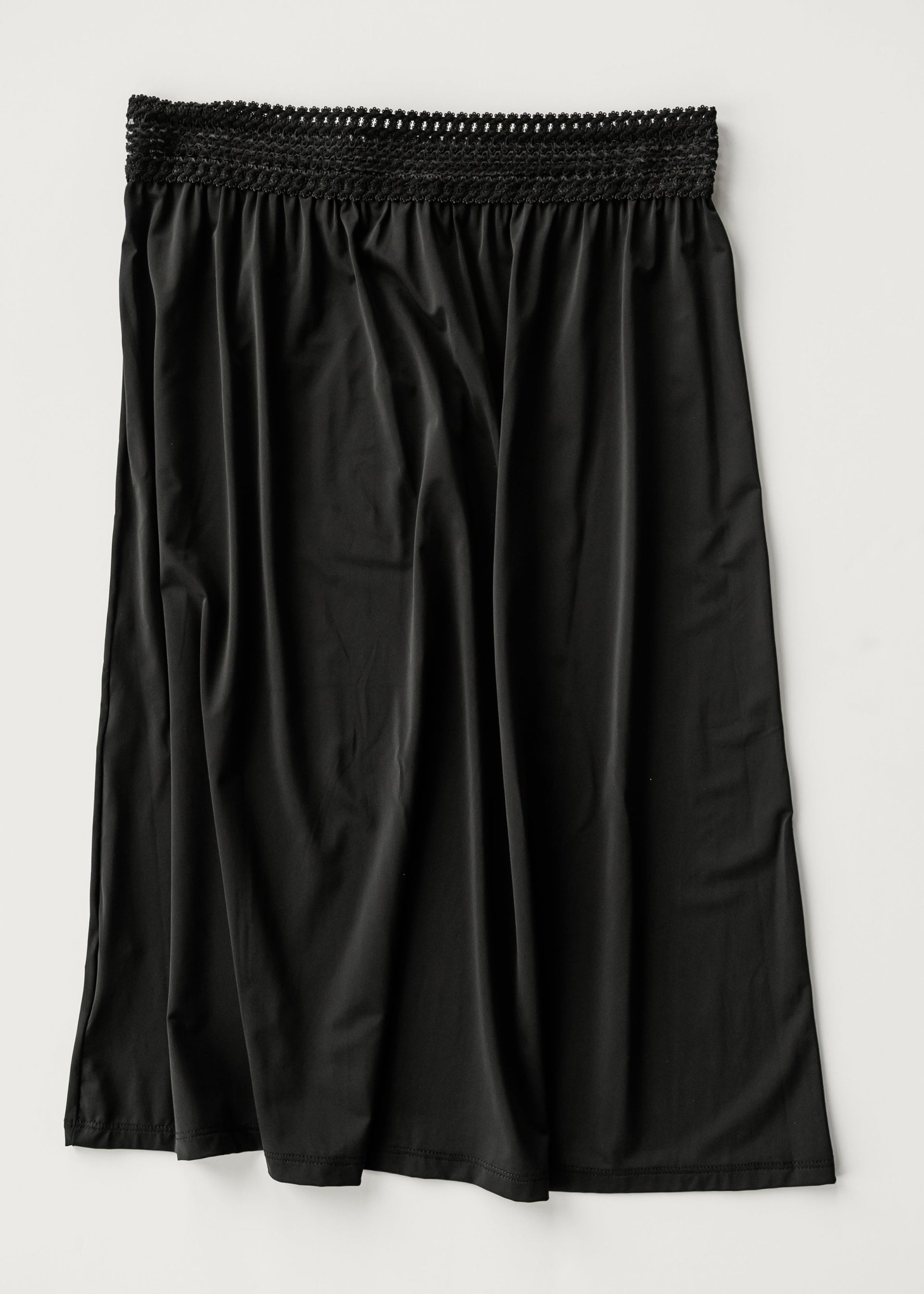 Black women's half slip with a soft stretch lace waistband, designed for comfort and smooth layering under clothing.