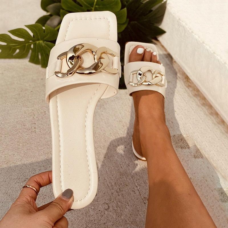 Close up of women's gold chain square toe block heel mules in a slip-on design