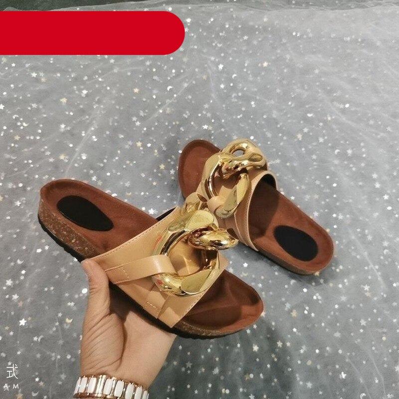 Women's minimalist flat leather slide sandals in beige with a decorative metal chain.