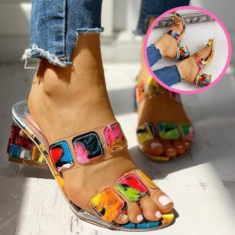 Women's modern square-toe block heel sandals with vibrant multi-colored patterns and clear transparent accents.