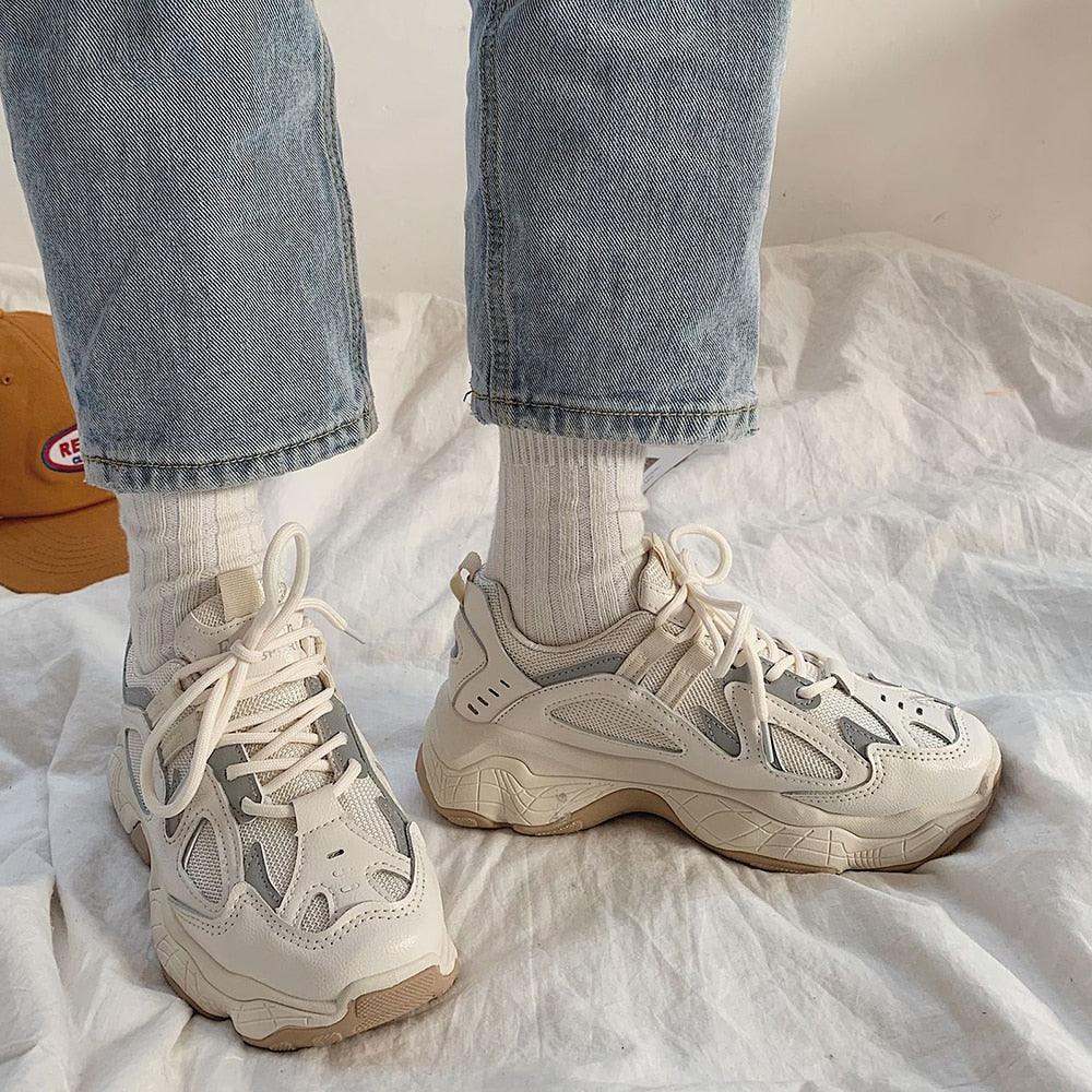 Women's chunky white platform sneakers with reflective details for streetwear style.