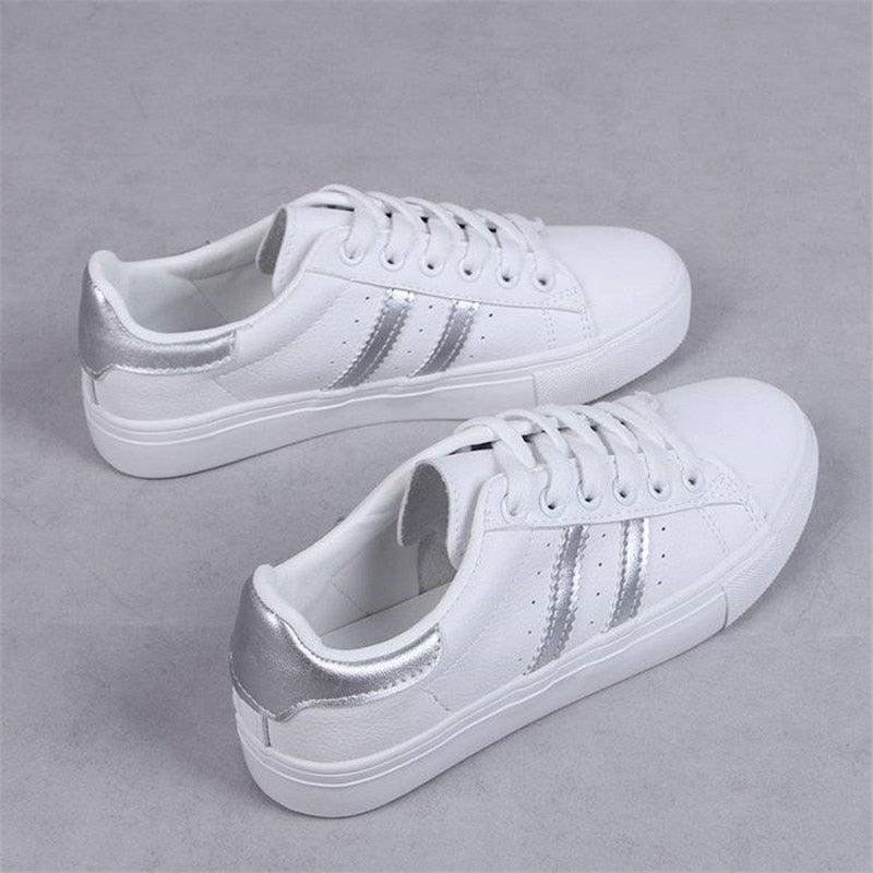 Pair of white eco-leather women's casual lace-up sneakers on a neutral background