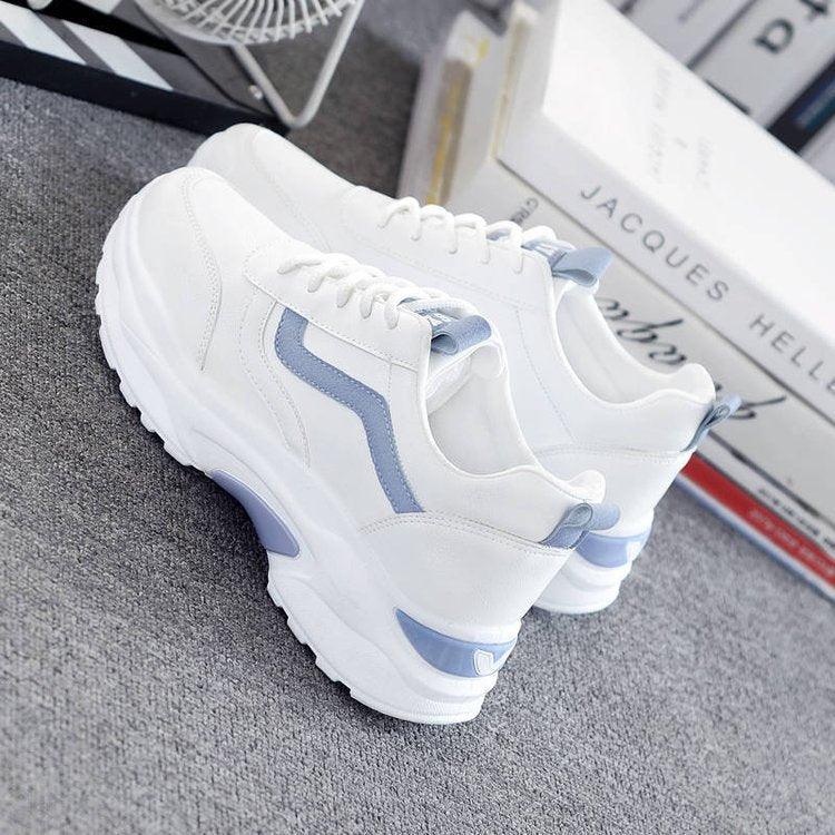 A pair of stylish white platform low-top lace-up sneakers for girls on a neutral background.