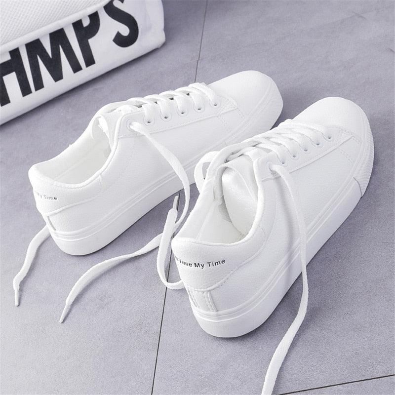 A pair of women's clean white leather platform sneakers with lace-up closure.