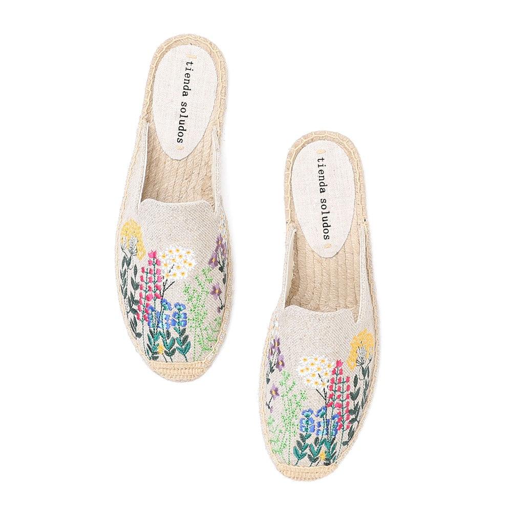 A pair of women's floral print hemp slides with orthopedic foam insoles and durable rubber soles