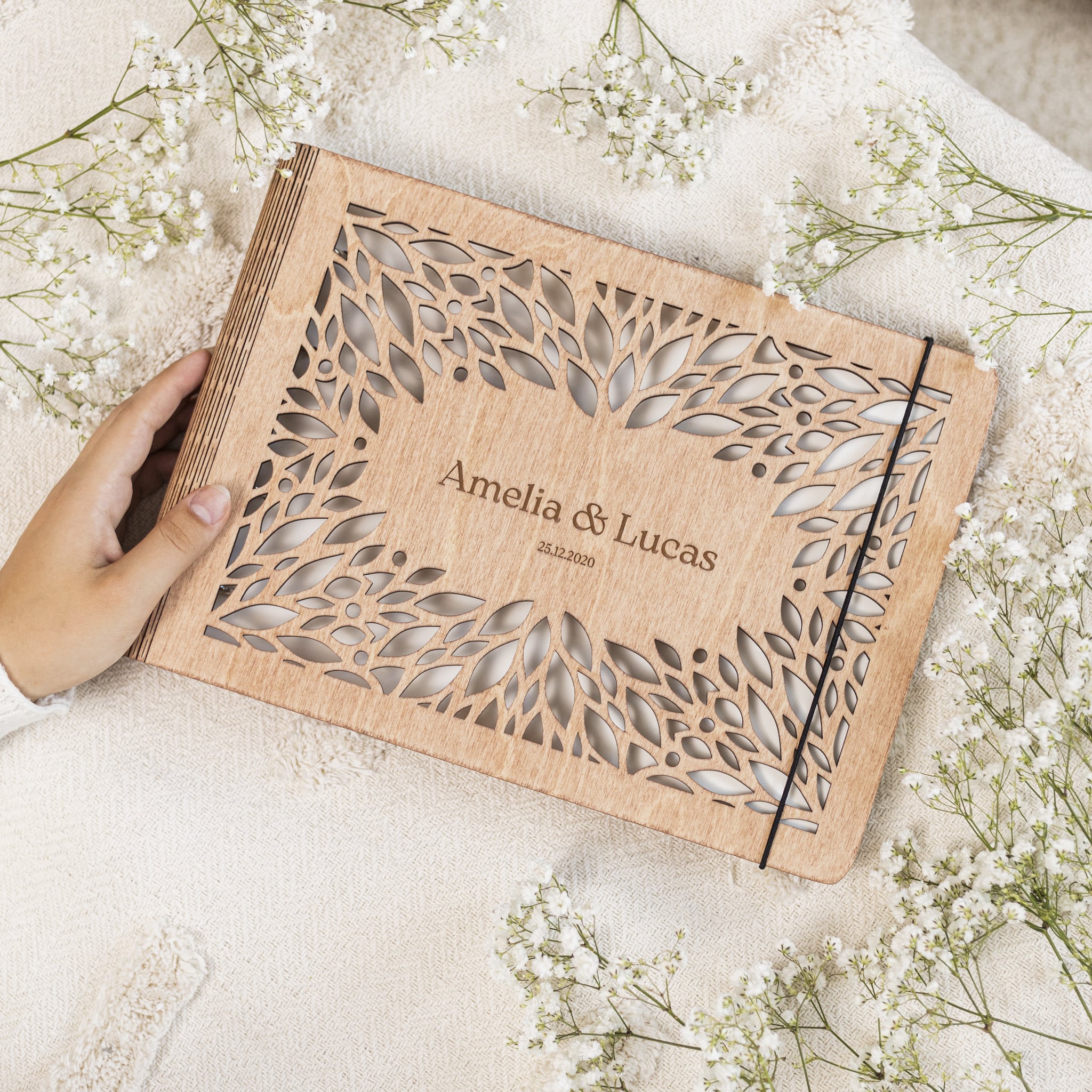 Close up of the Crownleaf wooden photo album with laser-engraved botanical leaf patterns.