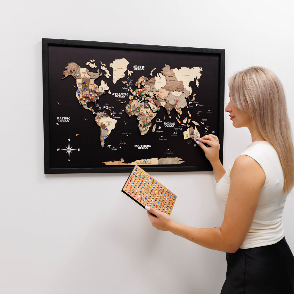 3D wooden world map in smoky brown and black finish displayed on a modern wall.