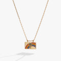 The Wizard of Oz flip-open charm necklace featuring a rainbow, hot air balloon, and the quote There's no place like home.