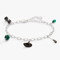 Silver-tone charm bracelet featuring Wizard of Oz Wicked Witch charms including a hat, broom, and green crystal