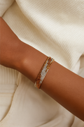Reta multi-strand wrap bracelet featuring gold, silver, and bronze polished metal coils.