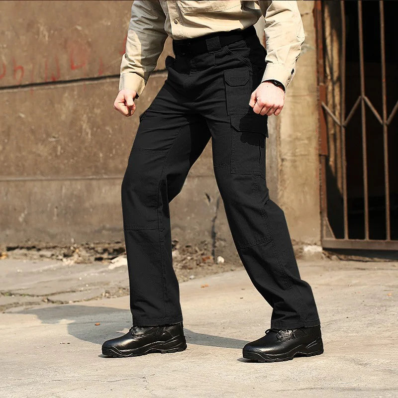 Model wearing black tactical cargo pants with reinforced pockets for outdoor activities