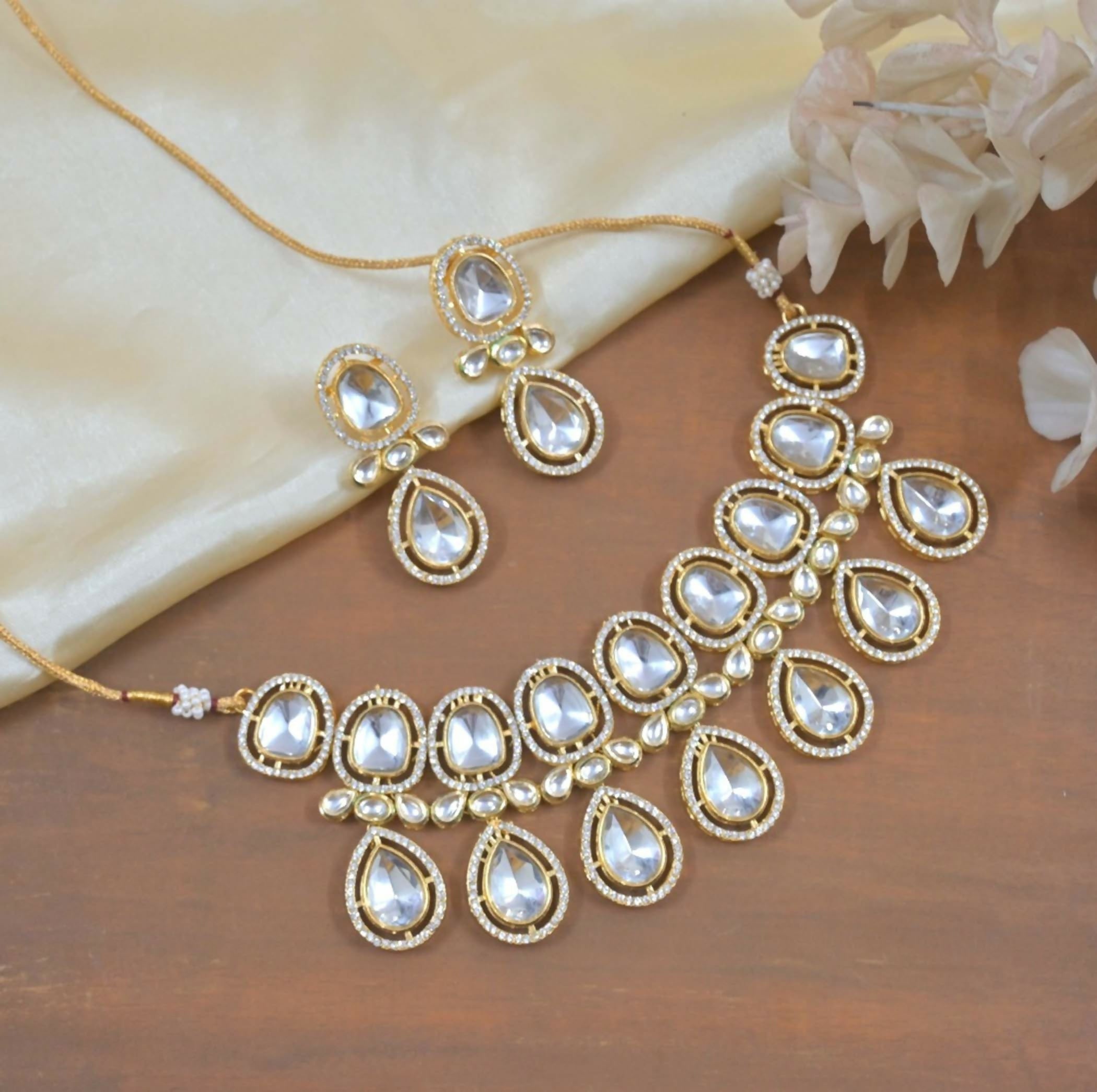 Polki Kundan traditional necklace and earring set in white and gold on a neutral background