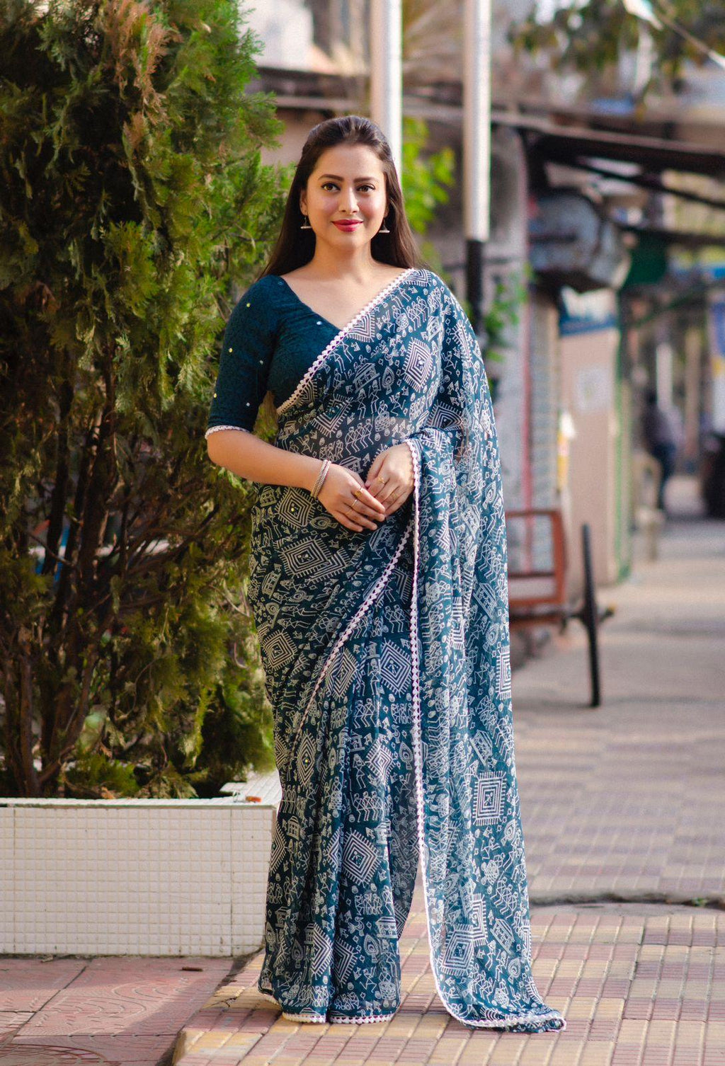 Rama and white poly georgette saree with ethnic Worli prints and aari mirror work details.
