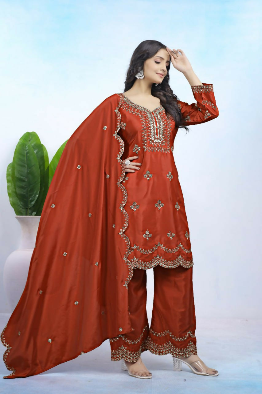 A woman wearing a maroon crepe embroidered kurti and matching sharara pants set
