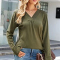 A woman wearing a long sleeve V-neck T-shirt in olive, featuring a loose fit and pleated neckline.