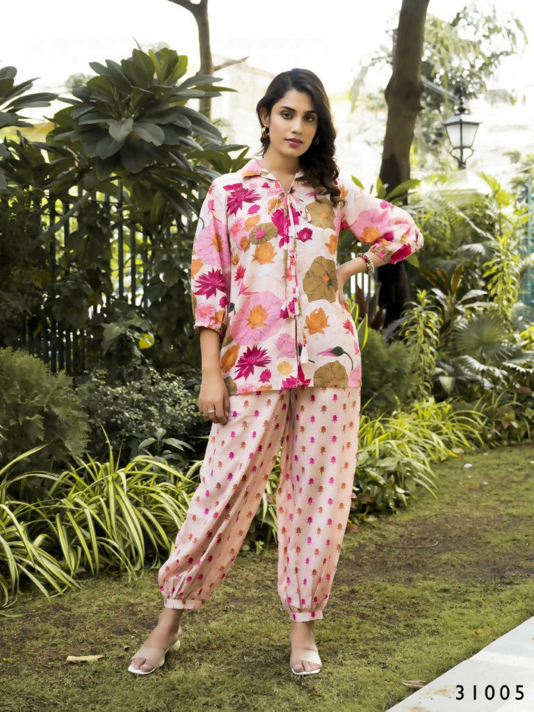 Woman wearing a relaxed fit muslin cotton co-ord set with multi-colored lotus floral print and collared button-down top