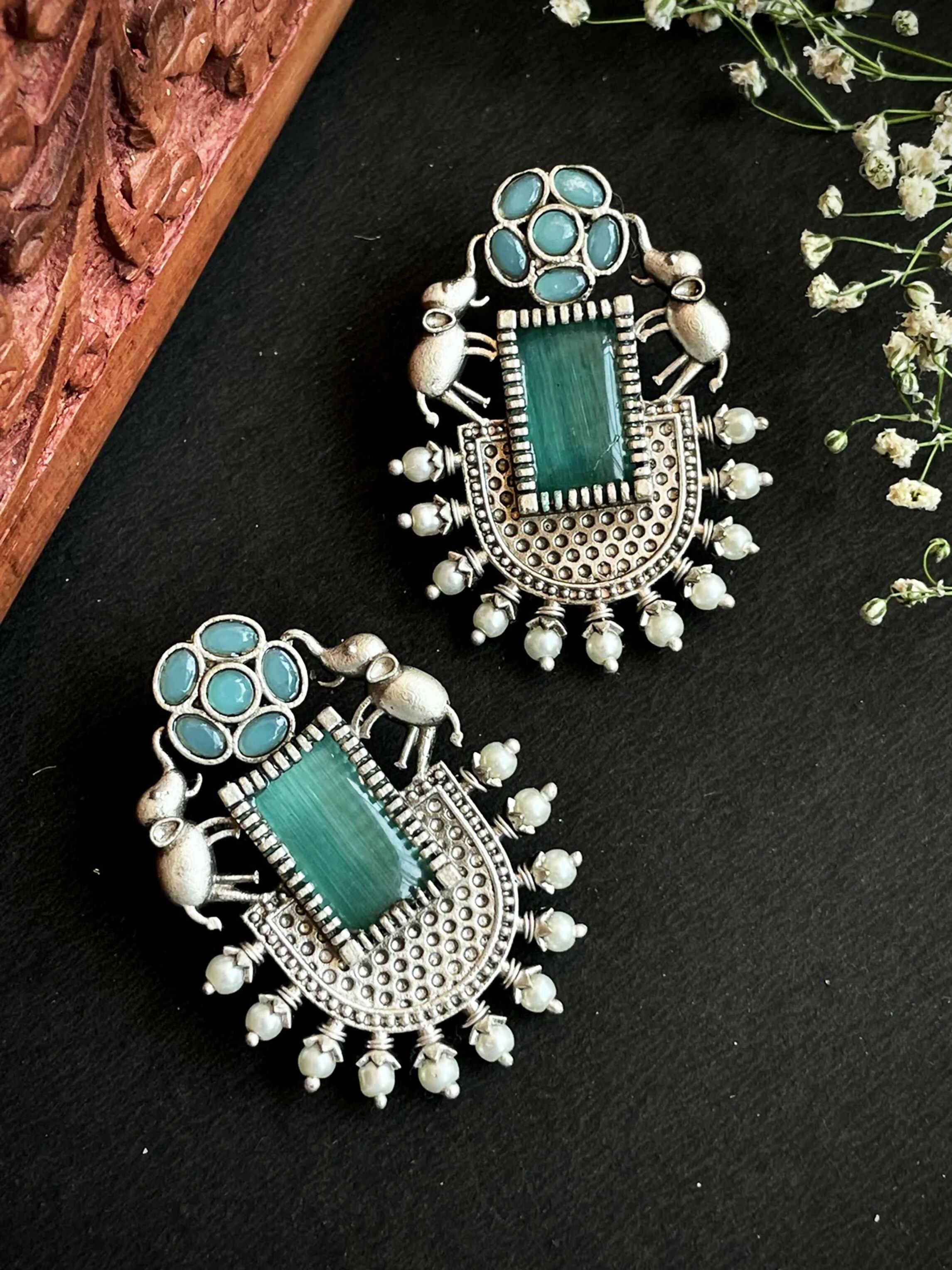 A pair of large, vibrant C Green Monalisa stone stud earrings featuring intricate brass craftsmanship.