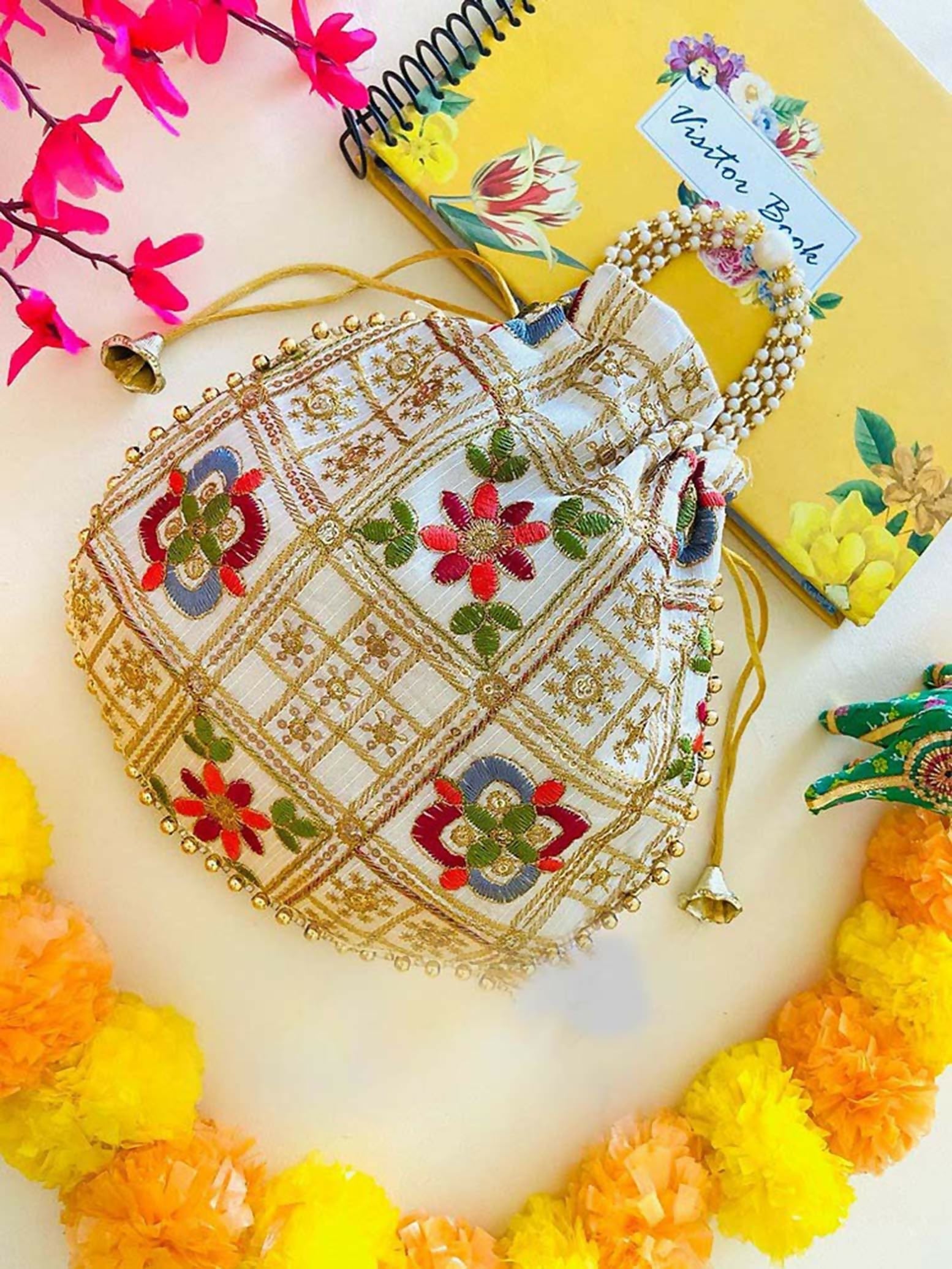 White and gold geometric patterned potli bag with drawstring closure for women.