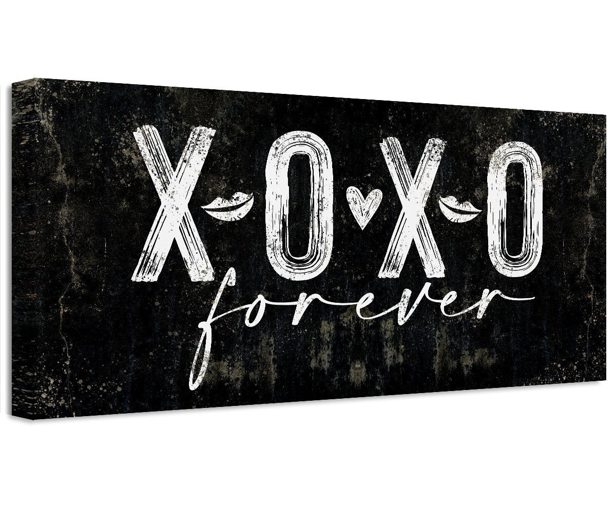 A black and white canvas print displaying XOXO Forever text, hanging above a bed as wall decor.