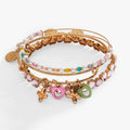 Set of three gold-tone bracelets featuring multicolor beads, a crystal heart charm, and XOXO charms